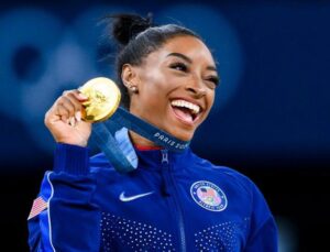 Congratulations:Simone Biles Poses with Her Medals in Mini White Dress...see more 👇